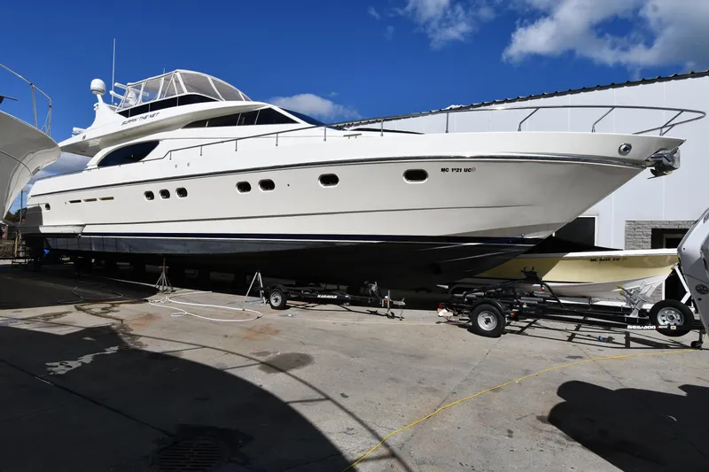 Slide: The Image of 2001 Ferretti Yachts 72 on trailer, docked outdoors under clear blue sky. - 1