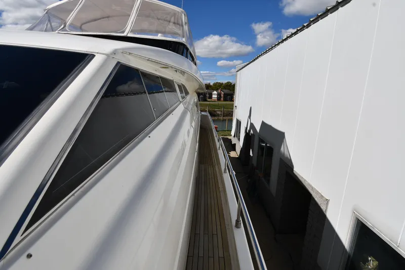 Slide: The Image of 2001 Ferretti Yachts 72 docked beside a white building under a blue sky. - 19