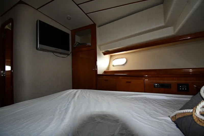 Slide: The Image of Interior cabin of 2001 Ferretti Yachts 72, featuring wood paneling and a mounted TV. - 48