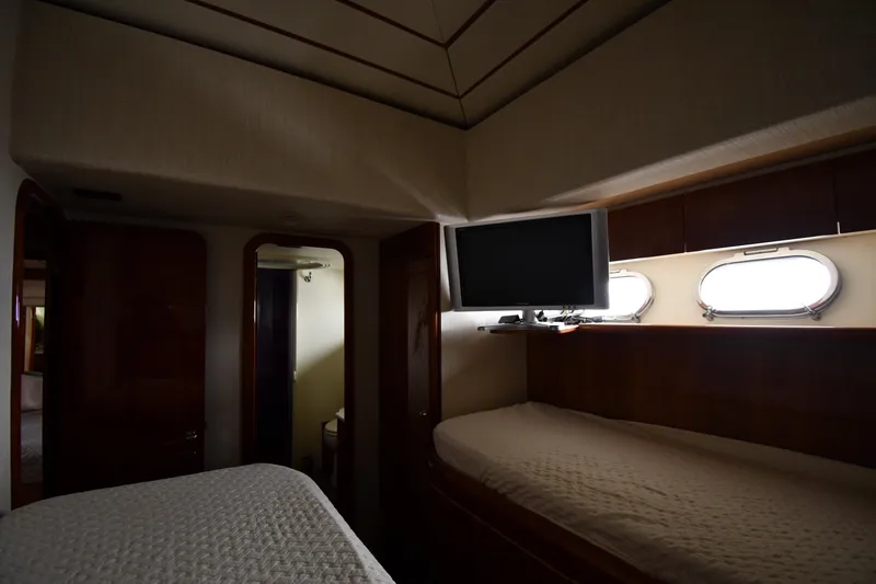 Slide: The Image of Interior of 2001 Ferretti Yachts 72, featuring cozy cabin with beds and porthole windows. - 64