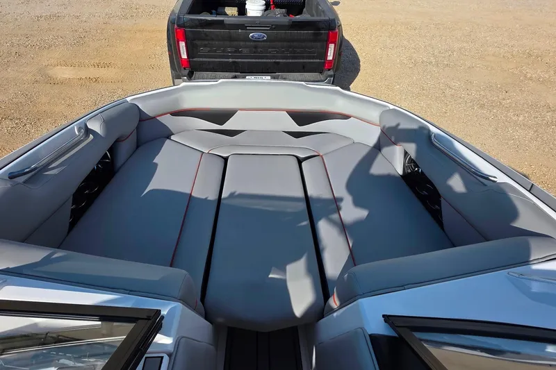 Slide: The Image of 2020 Moomba Makai boat interior with gray seating, parked near a black truck. - 19