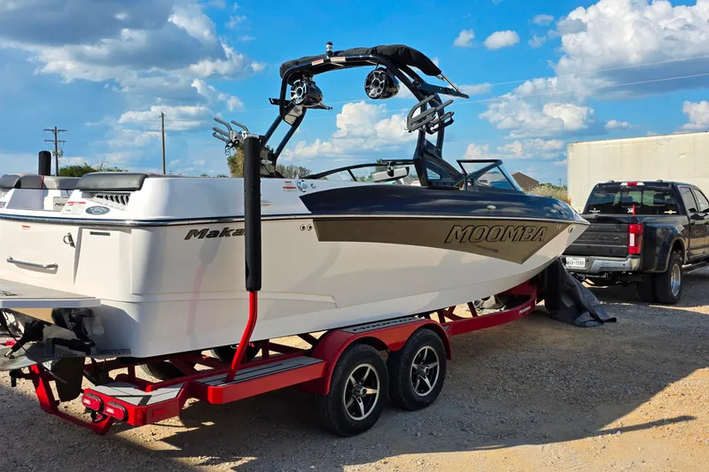 Slide: The Image of 2020 Moomba Makai boat on red trailer, parked outdoors under a blue sky. - 4
