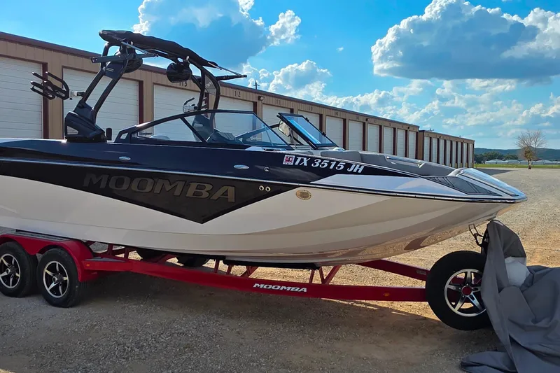 Slide: The Image of 2020 Moomba Makai boat on red trailer, parked outdoors under blue sky. - 7