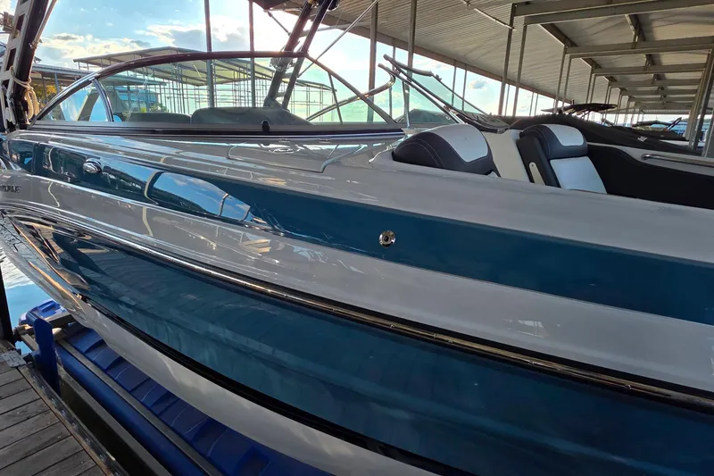 Slide: The Image of 2022 Crownline 255 SS SURF boat docked, showcasing sleek design and modern features. - 5