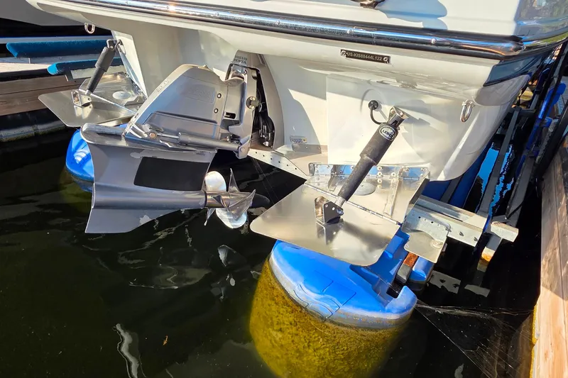 Slide: The Image of 2022 Crownline 255 SS SURF boat stern with propeller and trim tabs in water. - 6