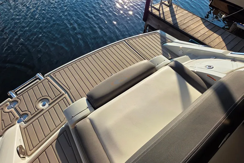 Slide: The Image of 2022 Crownline 255 SS SURF boat with spacious deck and comfortable seating by the water. - 7