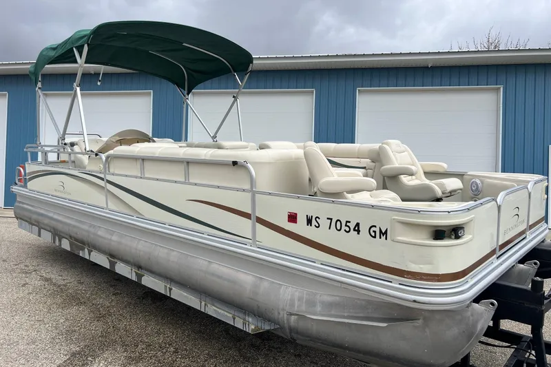 Slide: The Image of 2006 Bennington 2575 FS pontoon boat with canopy, parked near blue building. - 11