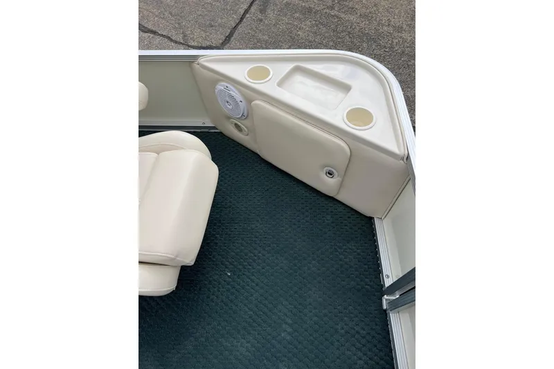 Slide: The Image of 2006 Bennington 2575 FS boat interior with beige seating and cup holders. - 12