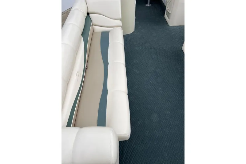 Slide: The Image of 2006 Bennington 2575 FS boat interior with white seating and blue carpet. - 18
