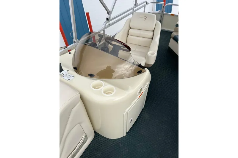Slide: The Image of 2006 Bennington 2575 FS boat interior with helm, windshield, and seating. - 25