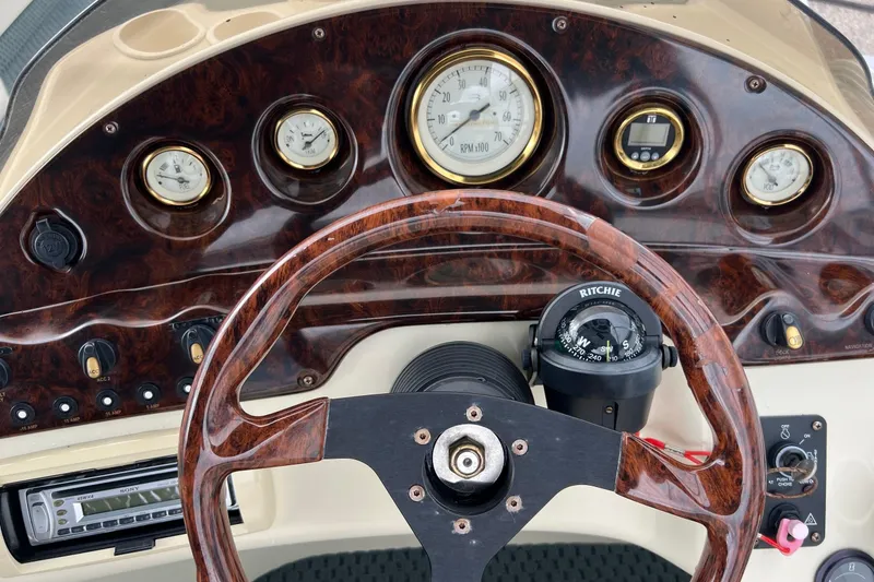Slide: The Image of Dashboard of a 2006 Bennington 2575 FS boat with wood finish and compass. - 27