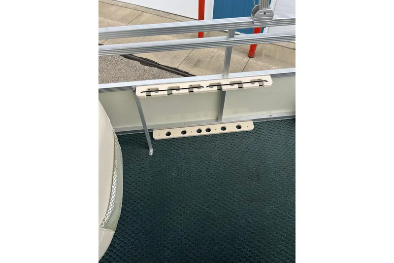 Slide: The Image of 2006 Bennington 2575 FS boat interior with rod holders and carpeted floor. - 30