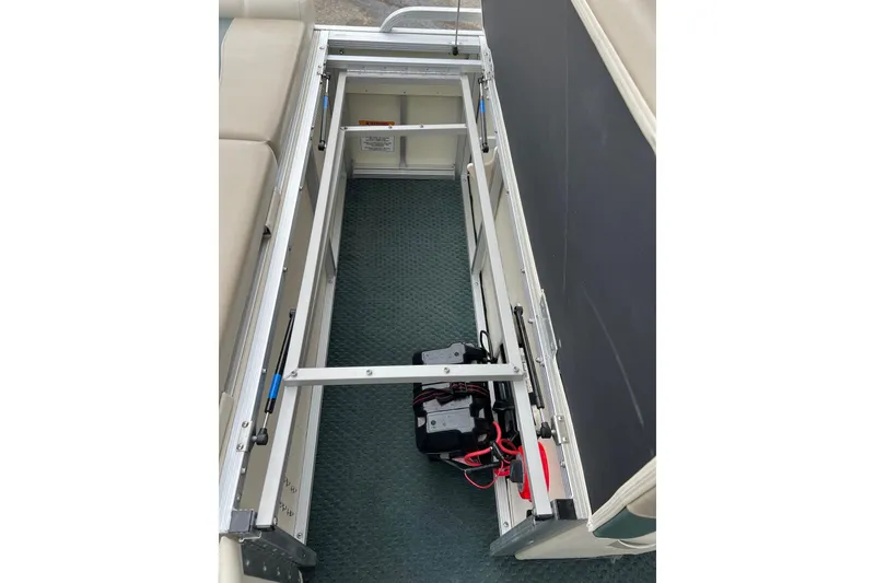 Slide: The Image of Open storage compartment in 2006 Bennington 2575 FS boat, showing battery and wiring. - 32