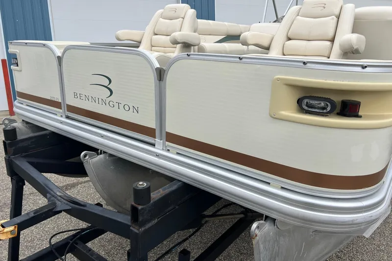 Slide: The Image of 2006 Bennington 2575 FS pontoon boat on a trailer, featuring beige seating and sleek design. - 46