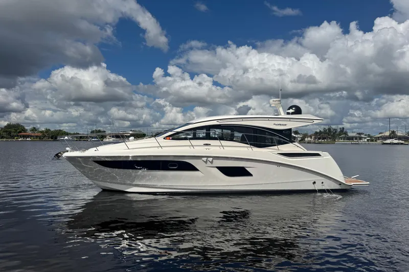 Slide: The Image of 2016 Sea Ray 400 Sundancer yacht on calm water under a partly cloudy sky. - 1