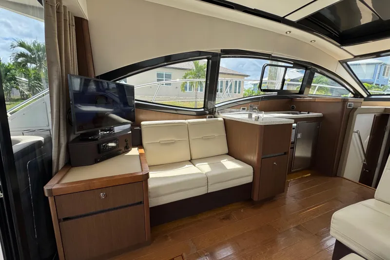 Slide: The Image of Interior of 2016 Sea Ray 400 Sundancer yacht with modern seating and kitchenette. - 12