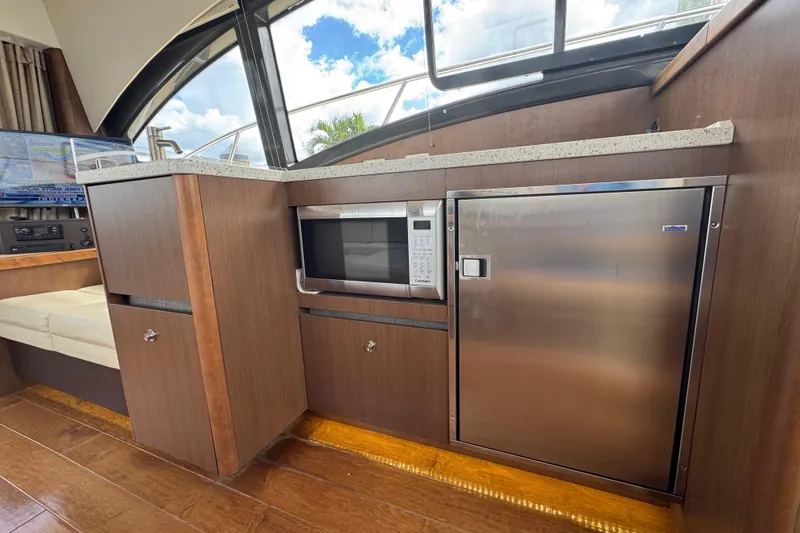 Slide: The Image of Interior of 2016 Sea Ray 400 Sundancer yacht with microwave and stainless steel fridge. - 19