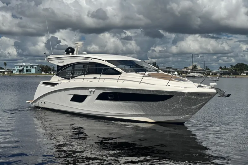 Slide: The Image of 2016 Sea Ray 400 Sundancer yacht on calm water under cloudy sky. - 2