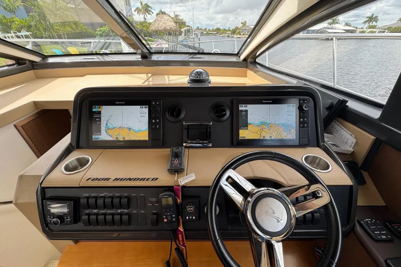 Slide: The Image of 2016 Sea Ray 400 Sundancer helm with dual navigation screens and modern controls. - 20