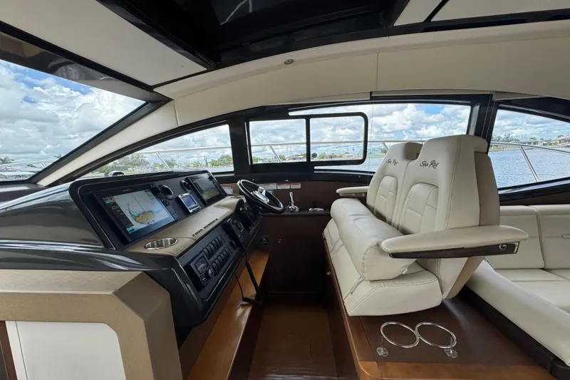 Slide: The Image of 2016 Sea Ray 400 Sundancer helm with modern navigation displays and luxurious seating. - 22