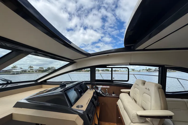 Slide: The Image of Interior view of 2016 Sea Ray 400 Sundancer yacht with luxurious seating and panoramic windows. - 23