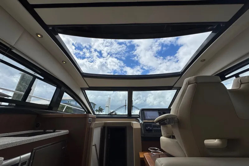 Slide: The Image of Interior view of 2016 Sea Ray 400 Sundancer yacht with skylight and luxurious seating. - 24