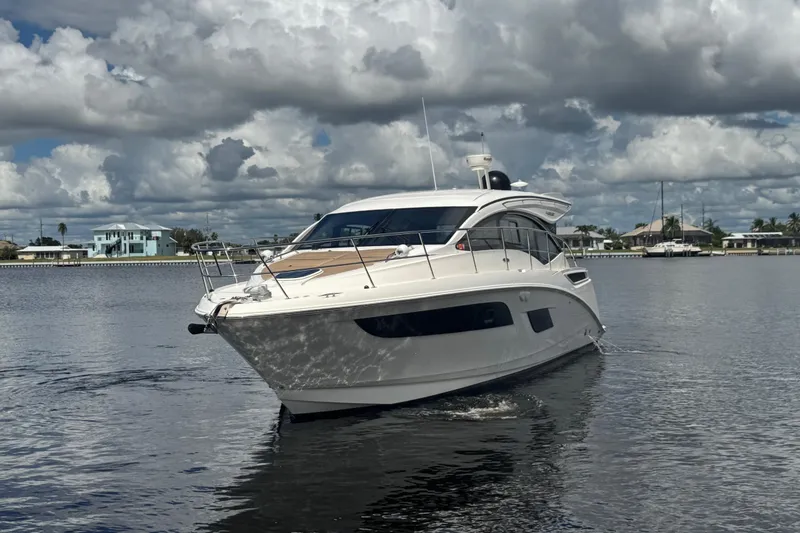 Slide: The Image of 2016 Sea Ray 400 Sundancer yacht cruising on a calm waterway under cloudy skies. - 3