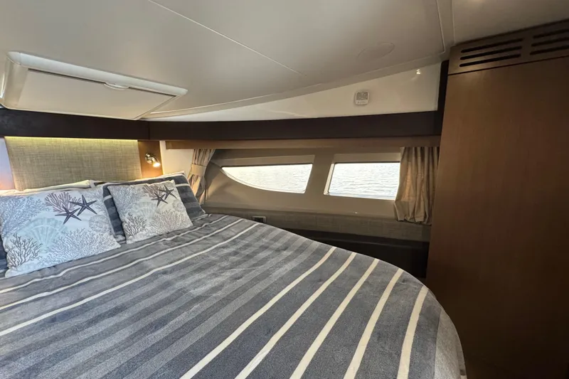 Slide: The Image of Luxurious bedroom interior of 2016 Sea Ray 400 Sundancer yacht with striped bedding. - 31