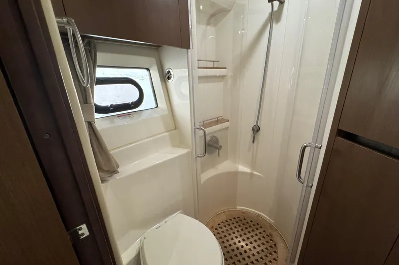 Slide: The Image of 2016 Sea Ray 400 Sundancer bathroom with shower, toilet, and window. - 33