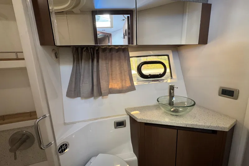 Slide: The Image of Luxurious bathroom in 2016 Sea Ray 400 Sundancer yacht with modern fixtures and window. - 39