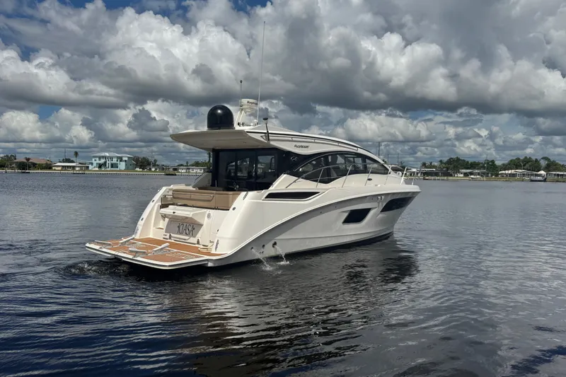 Slide: The Image of 2016 Sea Ray 400 Sundancer yacht cruising on a calm waterway under cloudy skies. - 4
