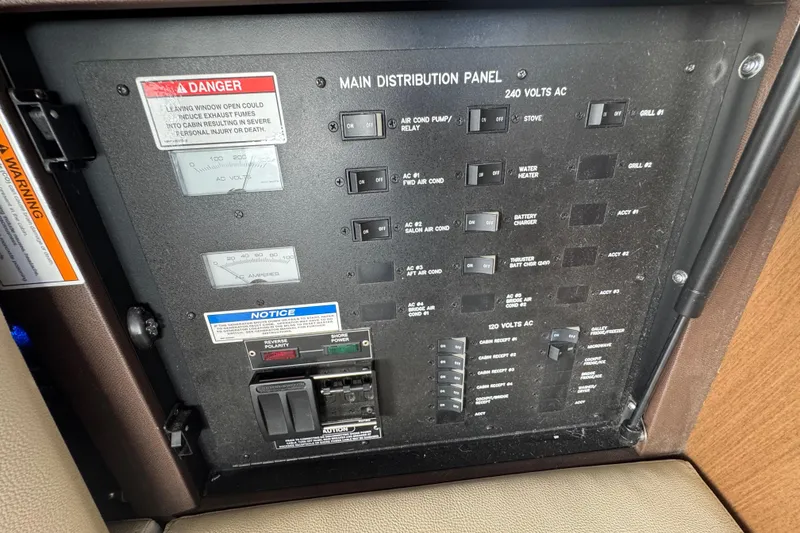 Slide: The Image of Main distribution panel on 2016 Sea Ray 400 Sundancer boat, showing switches and warnings. - 41