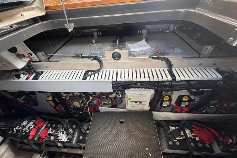 Slide: The Image of Engine compartment of a 2016 Sea Ray 400 Sundancer, showcasing batteries and wiring. - 44