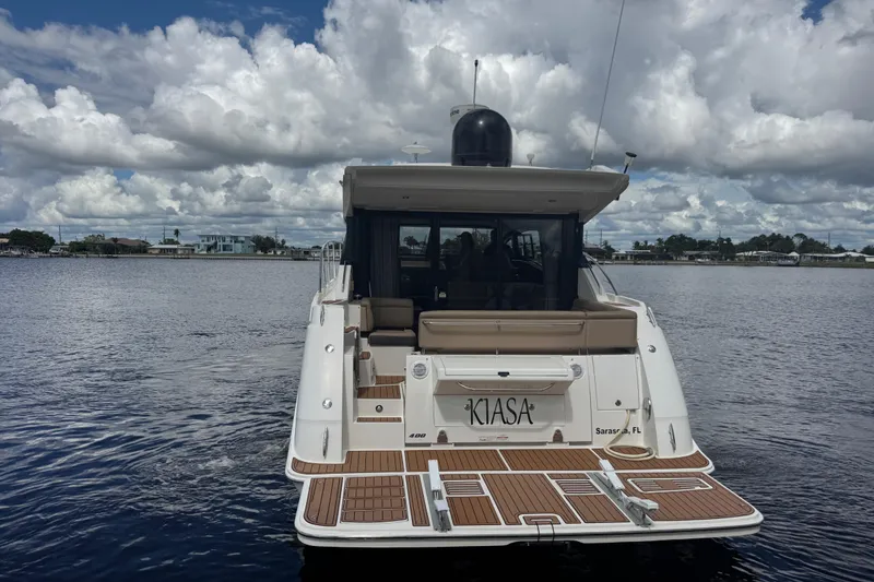 Slide: The Image of 2016 Sea Ray 400 Sundancer yacht on calm water under cloudy sky. - 5