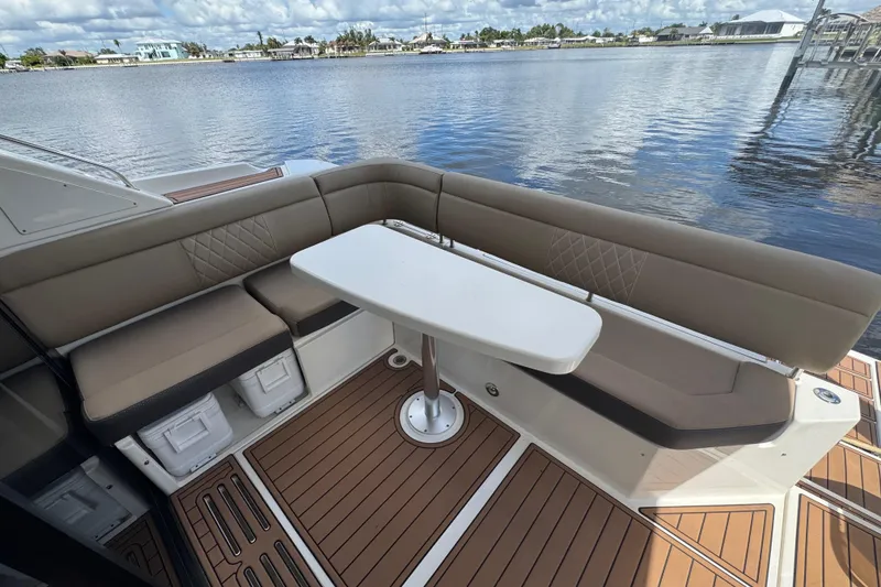 Slide: The Image of 2016 Sea Ray 400 Sundancer yacht with elegant seating and table on deck by the water. - 9