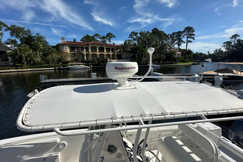 Slide: The Image of 2004 Edgewater 245CC boat with Raymarine equipment, docked near luxury waterfront homes. - 11