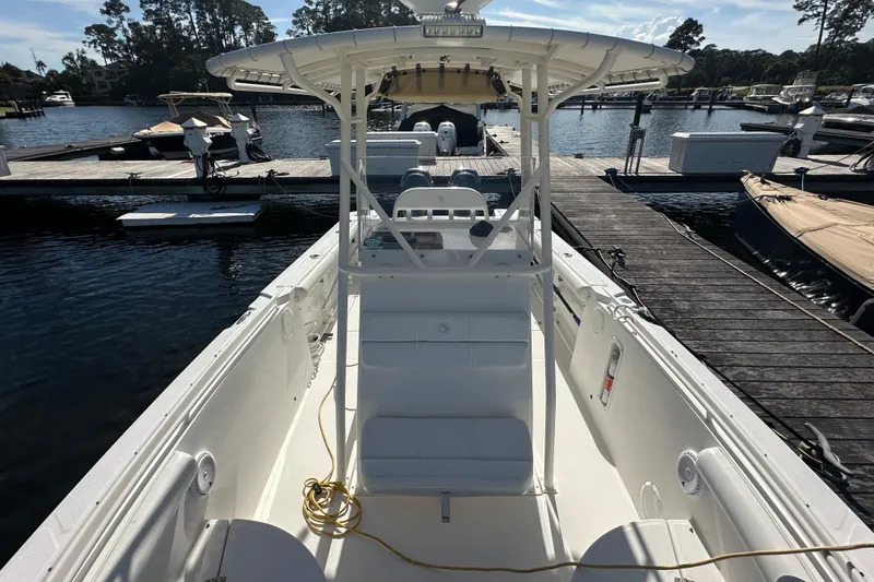 Slide: The Image of 2004 Edgewater 245CC boat docked at marina, featuring spacious deck and center console. - 12