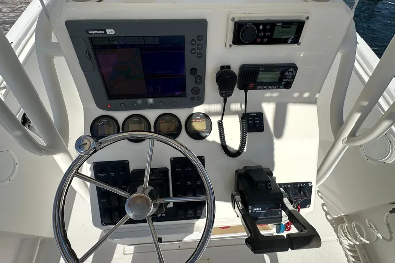 Slide: The Image of 2004 Edgewater 245CC boat dashboard with steering wheel, navigation, and communication equipment. - 17