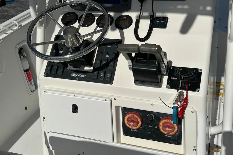Slide: The Image of Edgewater 245CC 2004 boat dashboard with steering wheel and controls. - 18