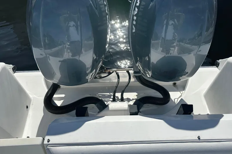 Slide: The Image of Twin Yamaha outboard engines on a 2004 Edgewater 245CC boat, reflecting sunlight on water. - 21