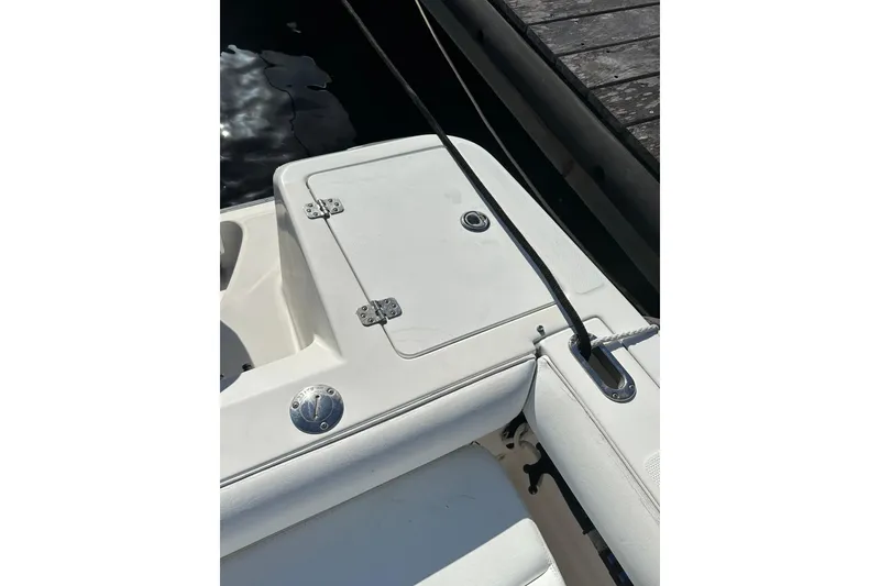 Slide: The Image of 2004 Edgewater 245CC boat deck with storage compartment and mooring line. - 22