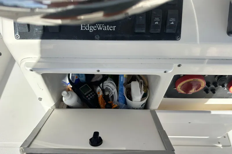 Slide: The Image of Edgewater 245CC 2004 boat dashboard with storage compartment and control panel. - 23