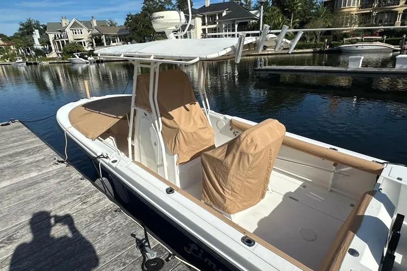 Slide: The Image of 2004 Edgewater 245CC boat docked, covered seats, scenic waterfront background. - 24