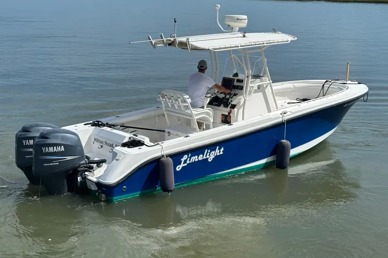 Slide: The Image of 2004 Edgewater 245CC boat with dual Yamaha engines on calm water. - 5