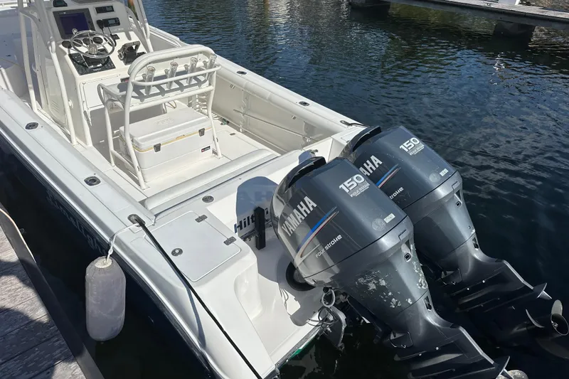 Slide: The Image of 2004 Edgewater 245CC boat with twin Yamaha 150 engines docked on water. - 8