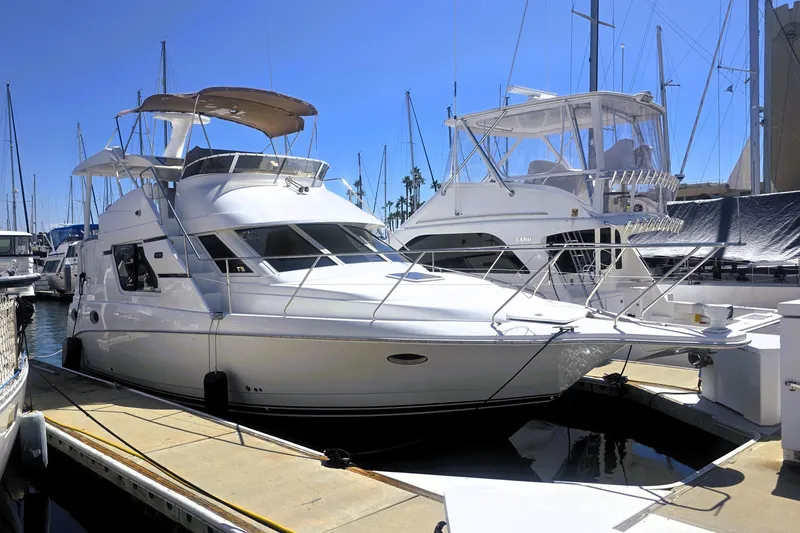 The Image of 1998 Silverton 352 Motor Yacht docked at marina under clear blue sky. - 0
