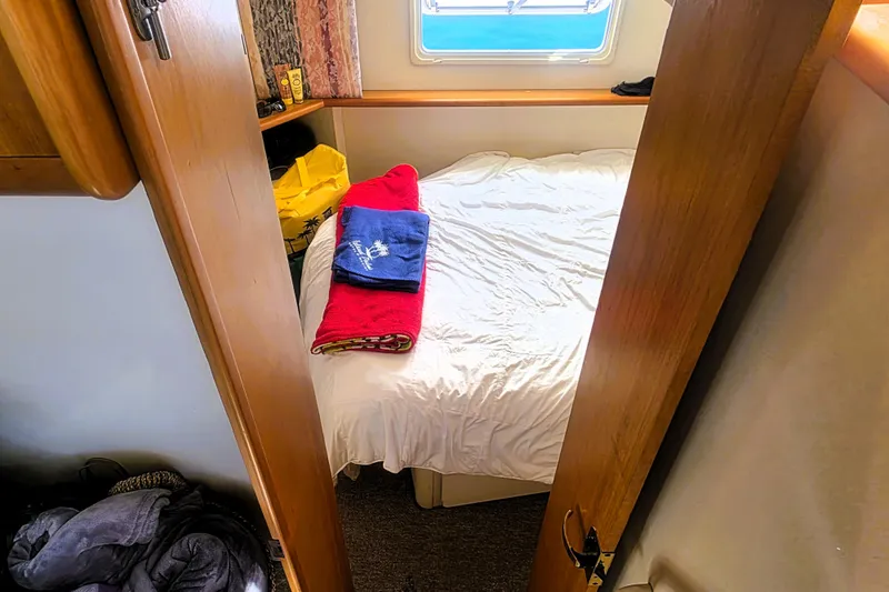 Slide: The Image of Cozy cabin interior of 1998 Silverton 352 Motor Yacht with bed and towels. - 15