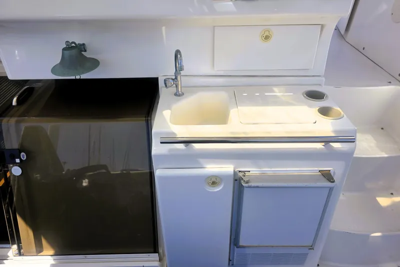 Slide: The Image of 1998 Silverton 352 Motor Yacht kitchenette with sink, fridge, and storage. - 3