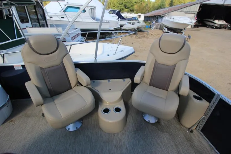 Slide: The Image of 2022 Sylvan L3 LZ boat interior with two beige captain chairs and cup holders. - 12