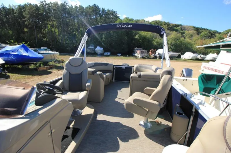 Slide: The Image of 2022 Sylvan L3 LZ pontoon boat with spacious seating, parked outdoors. - 13